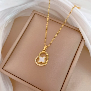 Detail of gold heart pendant with zircon accents and white star center on a fine chain