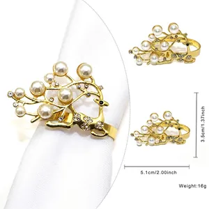 Golden reindeer napkin ring with pearls and rhinestones on a white fabric napkin