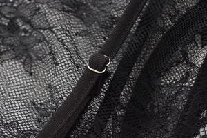 Detail shot of black lace top with intricate floral patterns and silver adjustable buckles