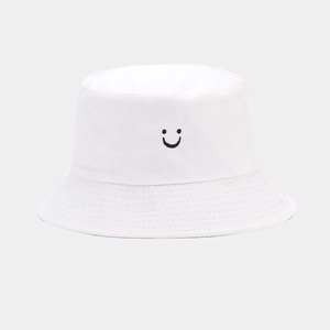 Close-up of minimalist black smile embroidery on white canvas bucket hat texture