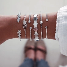 Silbernes Armband-Set mit Blatt-Design und geometrischen Wellenmustern am Handgelenk