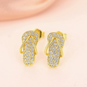 Macro-detail van gouden slippers oorbellen met sprankelende micro-pave zirkoniasteentjes