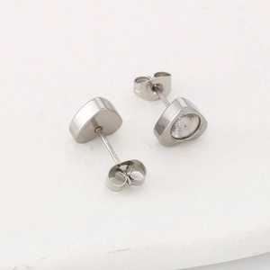 Macro shot of silver stainless steel heart studs with butterfly backs on white background