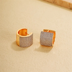 Macro shot of gold U-shaped hoop earrings with micro-pave white zircon stones