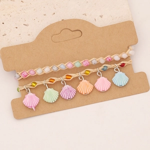 Détail d'un ensemble de bracelets tissés bohèmes avec coquillages en résine colorés