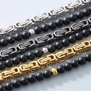 Detailed macro view of Byzantine chain links and matte black beads in gold and silver