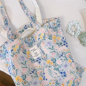 Detail shot of canvas tote bag featuring colorful floral and rabbit illustrations