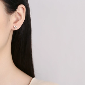 925 silver bow stud earrings with white pearl and sparkling crystals on model