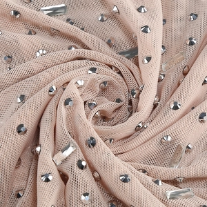 Macro detail of nude mesh fabric with sparkling silver rhinestones for a two-piece set