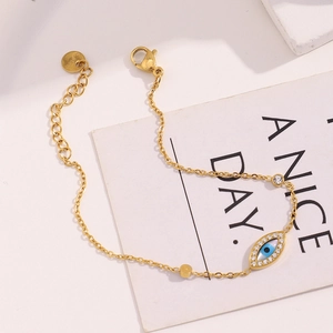 Detail of 18K gold plated stainless steel evil eye bracelet with blue enamel and crystals