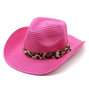 Detailed texture of pink straw cowboy hat with stylish leopard print ribbon and bow