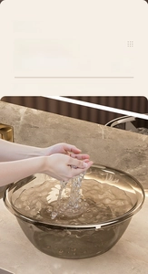 Detail of high-capacity amber transparent basin on marble countertop for bathroom