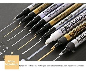Macro detail of Sakura Pen-touch metallic markers showing gold silver and white ink strokes