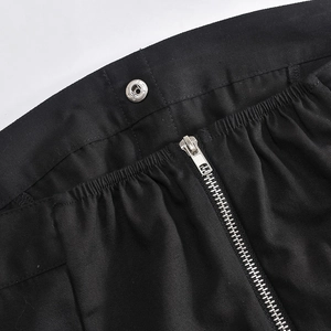 Macro view of black twill fabric texture with silver snap buttons and zipper closure