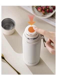 Detail of white 316 stainless steel thermos with push-button lid and portable strap