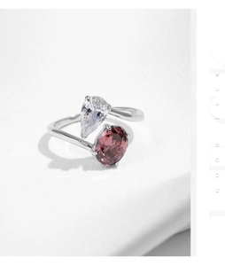 Macro shot of S925 silver ring featuring a pear-cut clear gem and oval brown stone