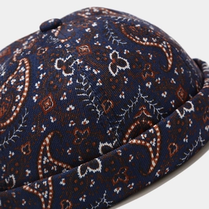 Macro shot of dark blue paisley pattern fabric on a retro miki hat with dome button