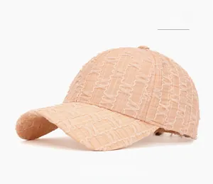 Detail of light pink seersucker baseball cap showing the textured waffle pattern fabric