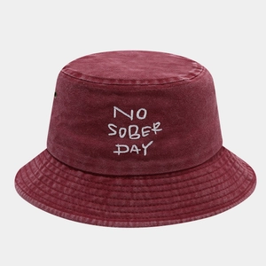 Close-up of wine red washed cotton bucket hat with white embroidery and metal eyelets