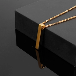 Macro shot of minimalist gold square bar pendant necklace with sleek mirror reflection