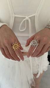Detailed shot of gold and silver sun swirl rings with hammered metal texture on fingers