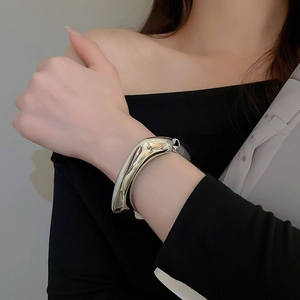 Close-up of a silver wide organic wave cuff bracelet with a mirror-polished finish