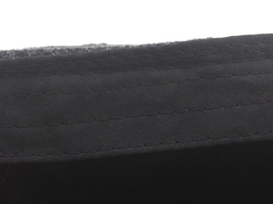 Macro detail of high-quality reinforced stitching on black plaid flat cap fabric