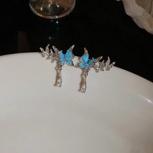 Detail of silver butterfly earrings with blue crystal inlay and teardrop zircon drop