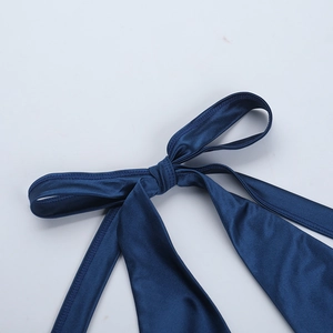 Detail of a dark blue satin strap with an adjustable bow knot design on summer dress
