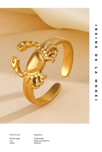 Macro d'une bague crabe ajustable en acier inoxydable doré sur un fond beige texturé