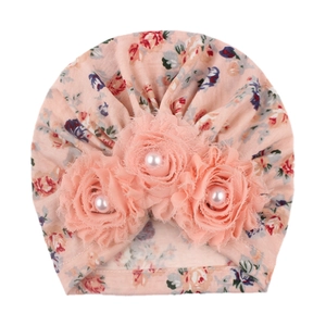 Pink floral baby turban hat with three large decorative fabric flowers and center pearls