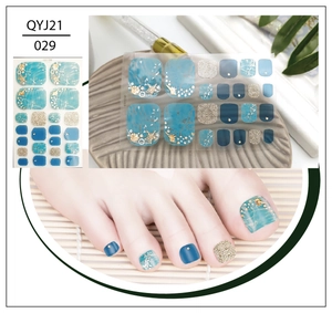 Detail of blue ocean-themed toe nail stickers with gold glitter and shell accents
