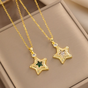 Detailed shot of star pendants with green and white gemstones in a jewelry box
