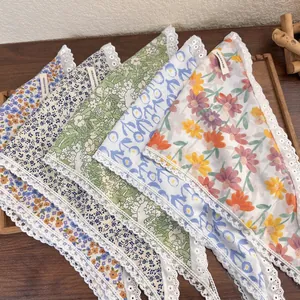 French retro floral cotton headscarf with white lace trim in a wooden tray