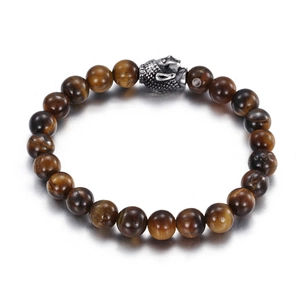 Tiger eye stone beaded bracelet with silver Buddha head pendant on white background