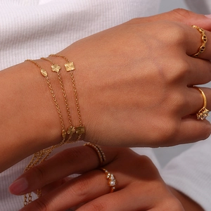 Minimalist 18K gold plated stainless steel bracelet set with geometric pendants on a model