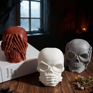 Three creative Halloween skull figurines in resin on a wooden table with art decor