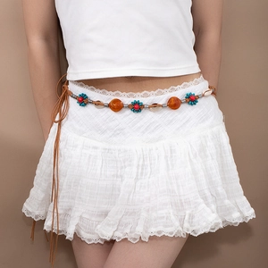 Chaîne de taille bohème tressée avec perles colorées et coquillages sur robe blanche