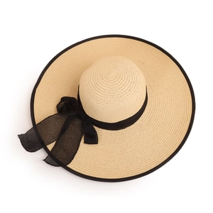 Detailed close-up of woven straw hat featuring a wide brim and elegant black chiffon bow