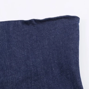 Détail macro du tissu denim bleu foncé avec une bordure effilochée de qualité