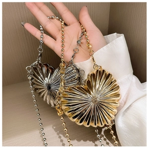 Detail of heart-shaped shell bags in gold and silver with radial 3D texture and bead chain
