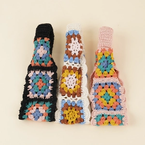 Detailed macro of handmade crochet headbands featuring vintage colorful floral patterns
