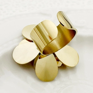 Detail of a golden wide floral ring featuring coral and white crystal petal motifs