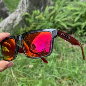 Detailed close-up of polarized sunglasses with red mirror lenses and transparent red temples
