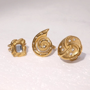 Detailed view of three 18k gold plated titanium steel rings with crystals on white stone