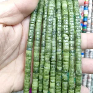 Macro detail of green natural stone spacer beads in a heishi disk shape for DIY jewelry