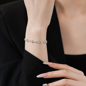 Close-up of zircon diamond flower bracelet on wrist with elegant silver metal links