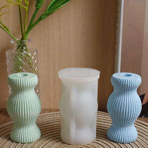 Detailed view of striped pillar silicone mold and finished plaster vases in hourglass shape
