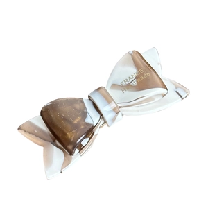 Vintage cream bow-shaped acetate hair claw with gold glitter and handmade engraving