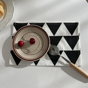 Detailansicht eines schwarz-weißen geometrischen Platzsets mit Keramikteller